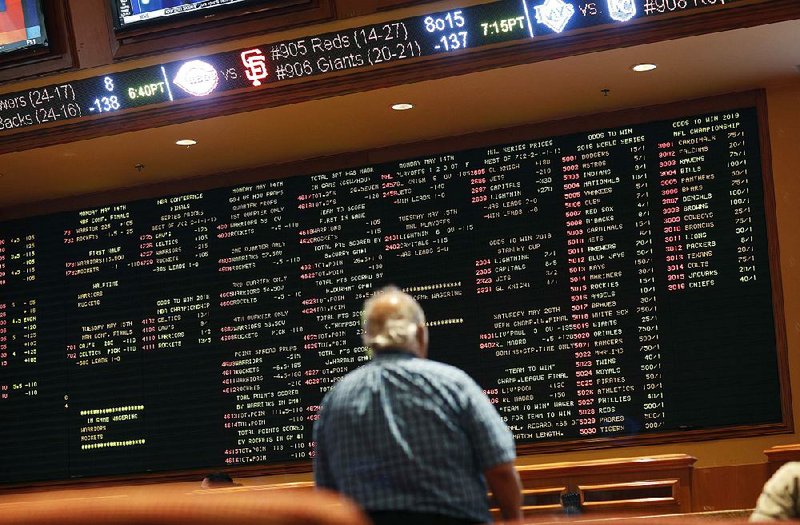 A man checks out the sports betting odds at a casino in Las Vegas on Monday, the day the U.S. Supreme Court indicated its leanings regarding the Constitution’s 10th Amendment. 