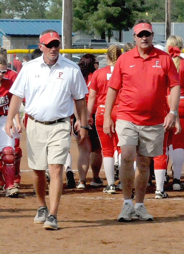 MARK HUMPHREY ENTERPRISE-LEADER Farmington head softball coach Randy Osnes (left) and assistant Steve Morgan walk off the field after the Lady Cardinals secured the school's first wins in 5A State tournament play this weekend. Farmington got victories over Magnolia (5-4) Thursday, Paragould (7-0) Friday, and De Queen (8-3) Saturday, to land the Lady Cardinals in Saturday's State 5A championship game to be played at 10 a.m. at the Benton High School Sports Complex, 1800 Benton Parkway, in Benton.