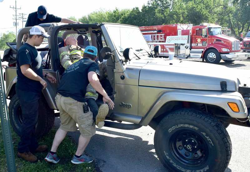 Westside Eagle Observer/MIKE ECKELS How many Decatur firefighters does it take to load a dummy into a jeep? Apparently, three, although two more joined in a short time later. The dummy, Decatur Fire Department's emergency response human analog, made the round trip ride to raise funds for the Arkansas Children's Hospital May 5.