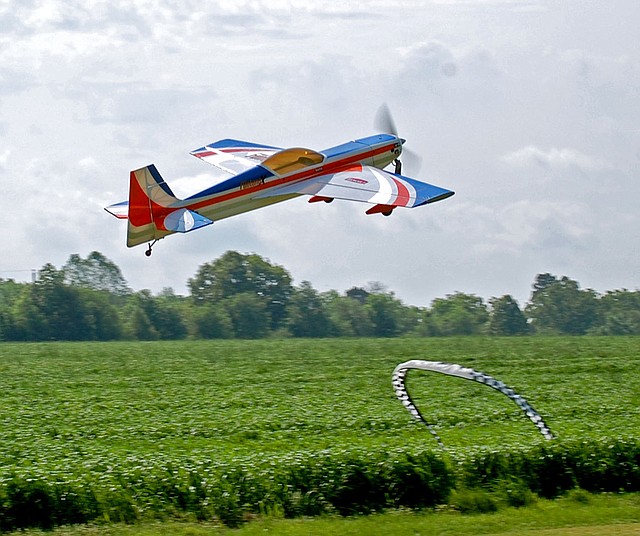 Janelle Jessen/Herald-Leader An aerobatic remote control plane owned by Jeremy Shrock of Gentry flew over the landing strip at Allen's Air Field during the Siloam Springs Radio Controlled Modelers semi-annual fun fly on Saturday.