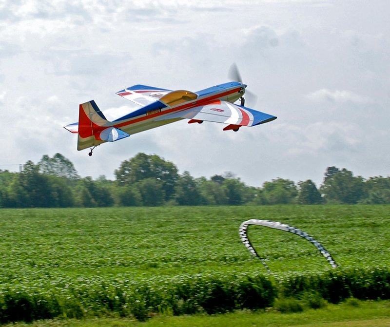 Janelle Jessen/Herald-Leader An aerobatic remote control plane owned by Jeremy Shrock of Gentry flew over the landing strip at Allen's Air Field during the Siloam Springs Radio Controlled Modelers semi-annual fun fly on Saturday.