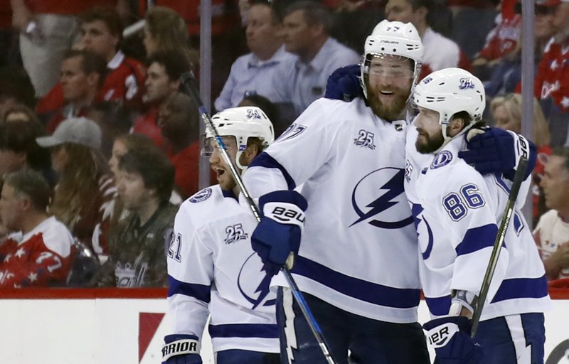 Tampa Bay Lightning center Brayden Point, left, defenseman Victor Hedman (77), from Sweden, and right wing Nikita Kucherov (86), from Russia, celebrate Kucherov's goal during the second period of Game 3 of the NHL Eastern Conference finals hockey playoff series against the Washington Capitals, Tuesday, May 15, 2018, in Washington. (AP Photo/Alex Brandon)
