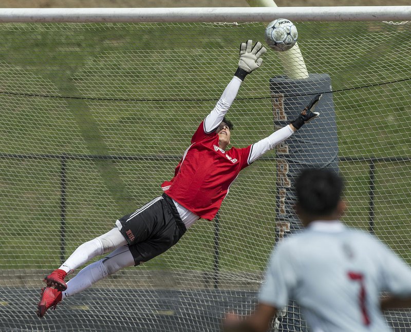 Fort Smith Northside goalkeeper Eric Flores leaps to make a save against Springdale High in the Class 7A state boys soccer tournament on Saturday in Rogers. Northside will take on Rogers High at noon Friday in the boys’ state championship match at Razorback Field in Fayetteville.