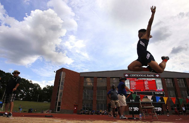 Ty Graser of Rogers Heritage leaps into the pit Wednesday during the long jump competition at the state high school decathlon in Cabot. Graser, who leads the decathlon by 38 points over Cary McClain of Conway, earned 691 points in the long jump by leaping 21 feet, 2¾ inches.