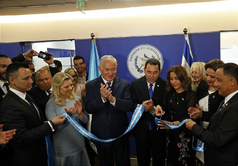 Israeli Prime Minister Benjamin Netanyahu (third from left); his wife, Sara (beside him); and Guatemalan President Jimmy Morales (center) watch Wednesday as Morales’ wife Hilda Patricia Marroquin cuts the ribbon dedicating the Guatemalan Embassy in Jerusalem. 