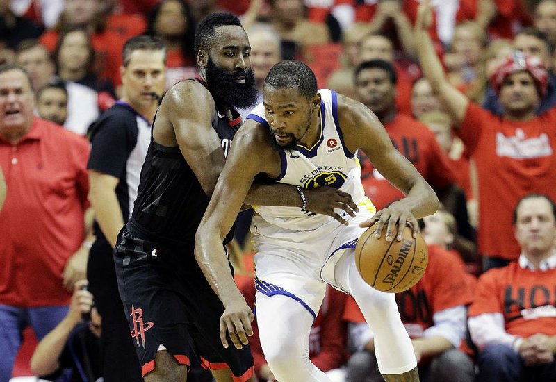 Golden State’s Kevin Durant (right) tries to work around Houston’s James Harden during Game 2 of the teams’ Western Conference finals game Wednesday in Houston. The Rockets won 127-105 to tie the series at 1-1.  