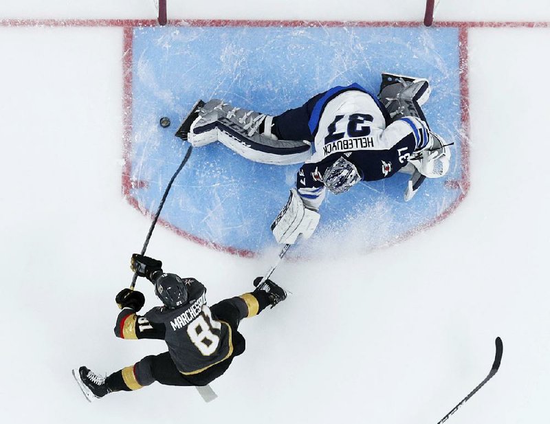 Vegas center Jonathan Marchessault scores past Winnipeg’s Connor Hellebuyck during the first period of the Golden Knights’ 4-2 victory Wednesday night in Las Vegas.  