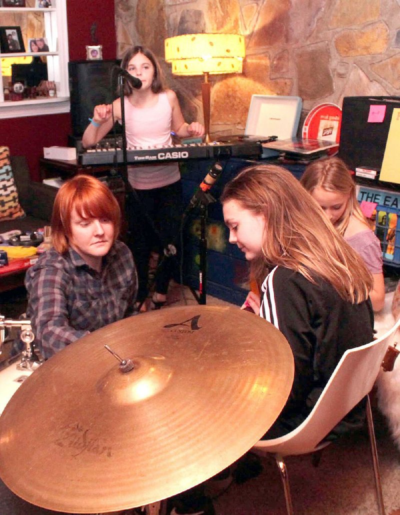 Instructor Melanie Castellano (clockwise from left) talks with students Ruby Duzan, Hannah Terry and Audrey Lowe at last year’s music summer camp for girls. A benefi t concert for this year’s camp, which is part of the Trust Tree Arts and Leadership Programs for Girls, will take take place Friday at the White Water Tavern in Little Rock. 
