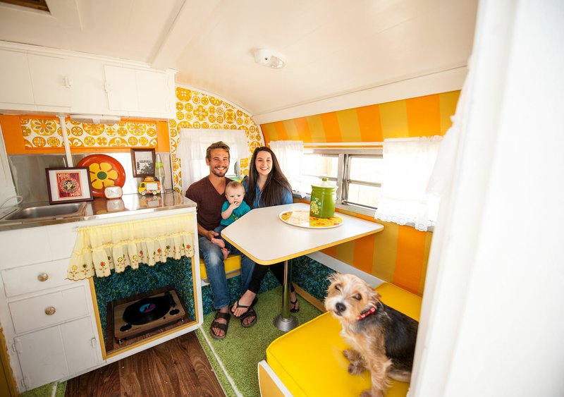 NWA Democrat-Gazette/Lara Jo Hightower Zack and Laura Kraus, with baby Gray and pup Ellie, are pictured in the Haight-Ashbury camper. Decorated in bright, sunny colors, it hearkens back to 1960s San Francisco. The Kraus family in June will open the Flamingo Springs trailer resort near Prairie Grove.