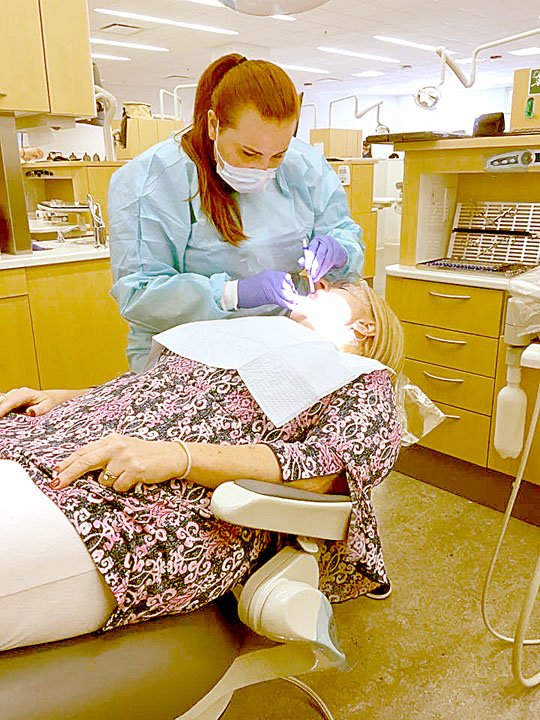 SUBMITTED PHOTO Hillary Craig, who is graduating from dental school on May 19, works on a patient during one of her dental school rotations. Craig is a 2010 graduate of McDonald County High School.