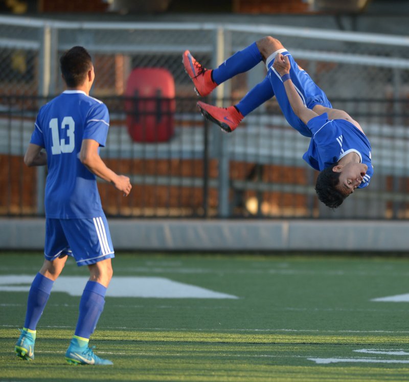 NWA Democrat-Gazette/ANDY SHUPE Rogers senior Willie Hernandez (right) flips Tuesday, April 10, 2018, after scoring a goal while celebrating with junior Felix Escobar during the second half against Springdale at Jarrell Williams Bulldog Stadium in Springdale. Hernandez and the Mounties will defend their 7A state soccer title at noon Friday against Fort Smith Northside.