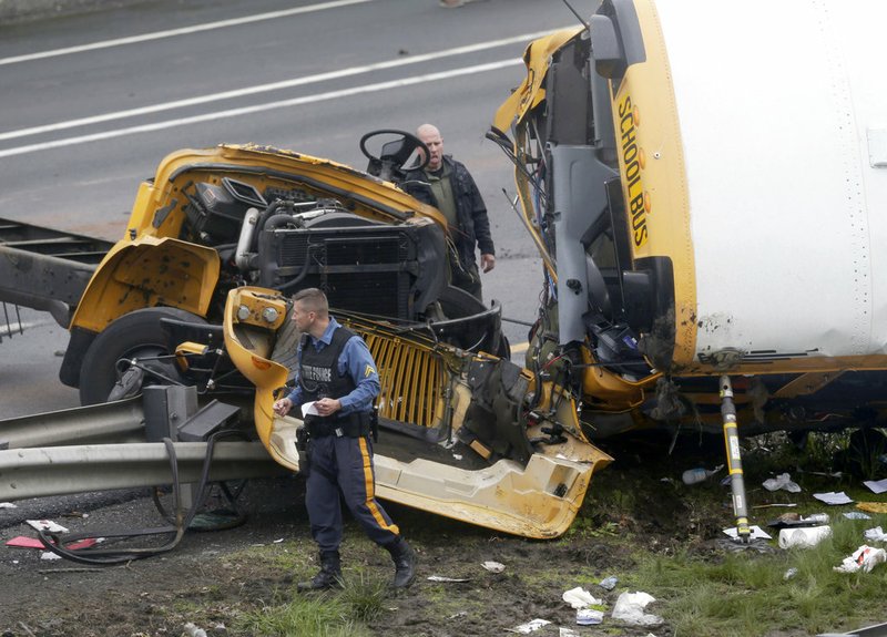 Emergency personnel work at the scene of a school bus and dump truck collision that injured multiple people on Interstate 80 in Mount Olive, N.J., on Thursday, May 17, 2018.