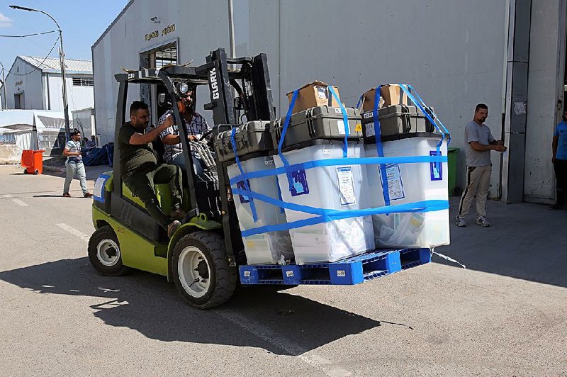 Workers transfer ballot boxes Thursday in Baghdad, where recent election results have the U.S. rethinking its dealings in Iraq.  