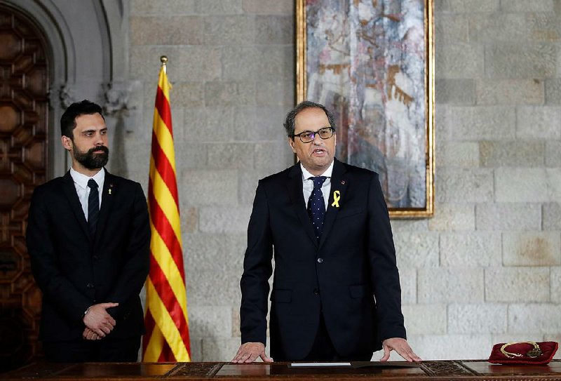 With Catalan parliament President Roger Torrent standing beside him, Catalan President Quim Torra speaks after being sworn into office Thursday in Barcelona.  
