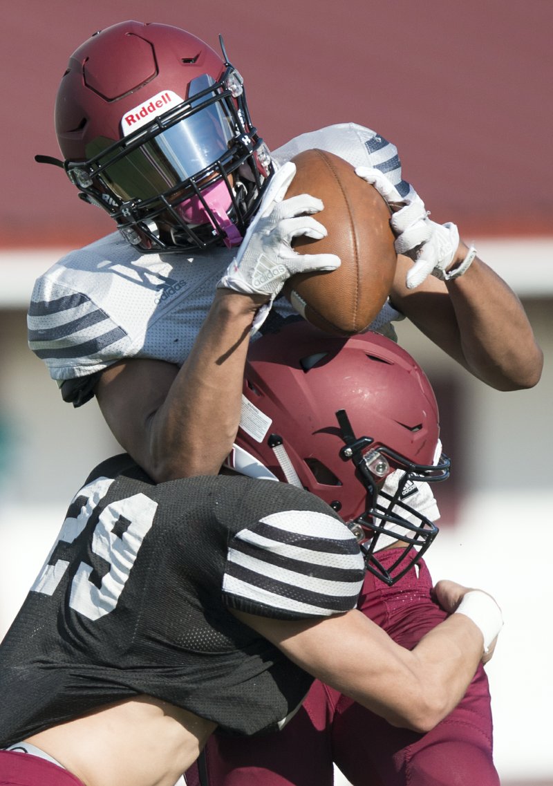 NWA Democrat-Gazette/CHARLIE KAIJO Springdale High School wide receiver Bryndell Cook (9) makes a catch as cornerback James Arce (29) tackles during the Red-White spring football game, Thursday, May 17, 2018 at Jarrell Williams Bulldog Stadium at Springdale High School in Springdale. 

