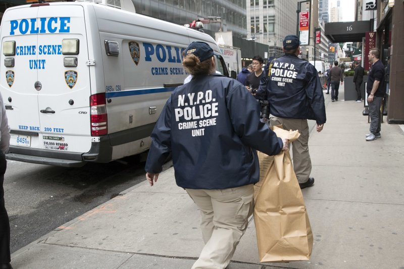 Members of the New York Police Department crime scene unit arrive at the Gotham Hotel, Friday, May 18, 2018, in New York. Police say a woman apparently jumped with her son from a window of the boutique hotel in New York City and both died. (AP Photo/Mary Altaffer)

