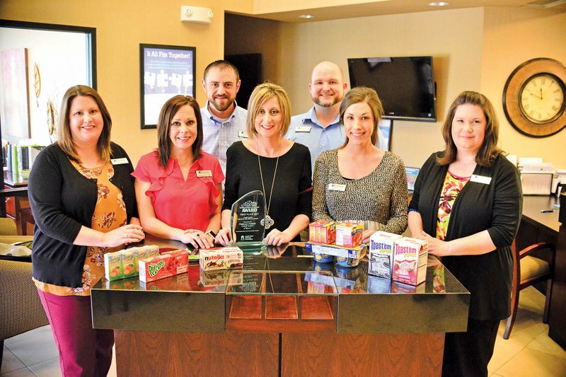 Patterson Federal Credit Union in Arkadelphia is the recipient of the Dora Maxwell Social Responsibility Award from the Credit Union National Association for the credit union’s involvement with Project CARE, a food drive to fill backpacks for needy children in the Arkadelphia School District. Employees include, front row, from left, Kyla Batson, member services officer; Nicole McGough, vice president of business development; Haley Nichols and Lauren Taylor, member services representatives; and Amy Jackson, member services officer; and back row, Shawn Cowart, CEO, and Clay Phillips, member services officer. The credit union accepts at its office nonperishable food items similar to those shown in this photograph.