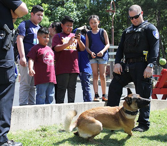 The Sentinel-Record/Rebekah Hedges EDUCATION IN MOTION: Joaquin Guillermo, left, a first-grader from Highland Oaks Elementary, and his brother, Abraham Guillermo, of Memphis, Tenn., throw a ball to Bear, Hot Springs police Officer Jonathan Smith's K-9, Friday during Education in Motion at Magic Springs Theme &amp; Water Park.