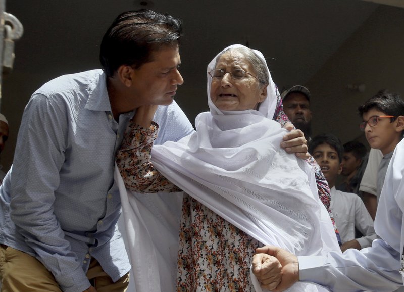 Abdul Aziz Sheikh, left, father of Sabika Sheikh, a victim of a shooting at a Texas high school, comforts to an elderly woman arriving for condolence to his daughter at his home in Karachi, Pakistan, Saturday, May 19, 2018. The Pakistani foreign exchange student is among those killed in the shooting, according to a leader at a program for foreign exchange students and the Pakistani Embassy in Washington, D.C. Megan Lysaght, manager of the Kennedy-Lugar Youth Exchange & Study Abroad program (YES), sent a letter to students in the program confirming that Sabika Sheikh was killed in the shooting. (AP Photo/Fareed Khan)