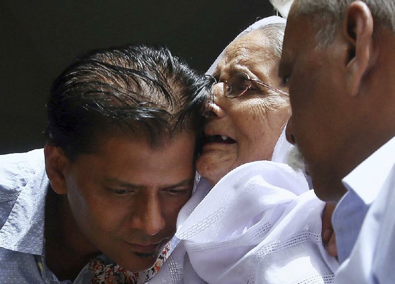 Aziz Sheikh hugs a woman sharing condolences Saturday at his home in Islamabad over the shooting death of his daughter, Sabika Sheikh. Sheikh said he found out about her death after seeing news reports and trying repeatedly to reach her on her phone. 
