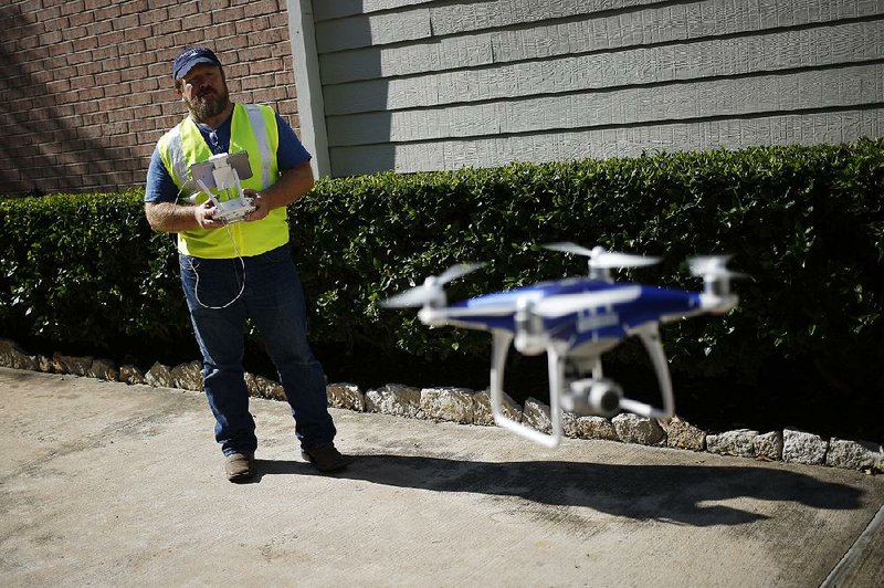 Sean Duff operates a Da-Jiang Phantom drone as he carries out a property inspection in September in Houston after Hurricane Harvey’s damage.  
