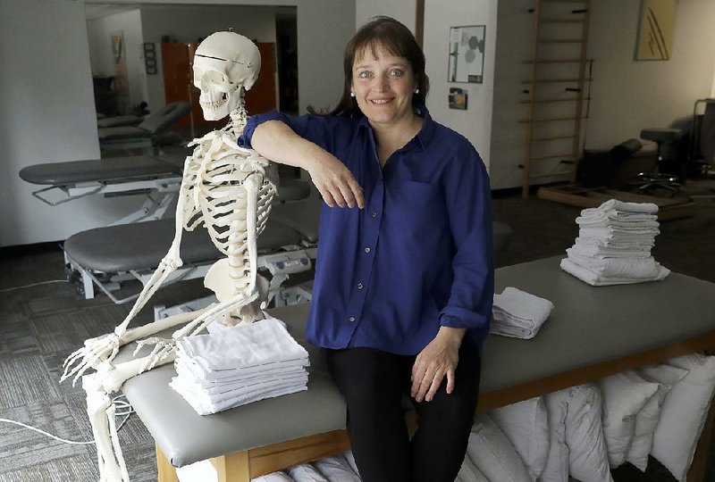 April Oury, owner of several Body Gears physical therapy centers, poses for a portrait earlier this month with her instructional skeleton George, in Chicago.  