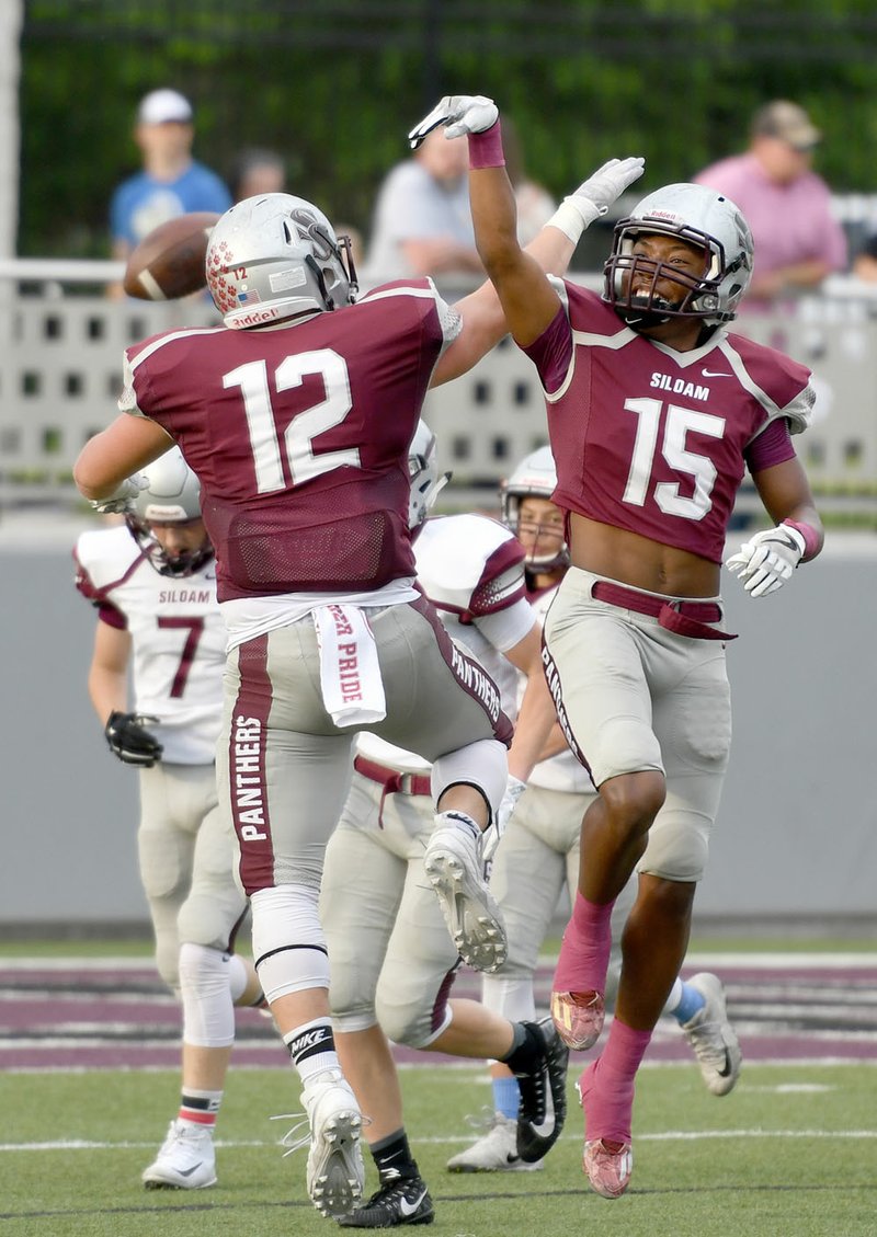 Bud Sullins/Special to Siloam Sunday Siloam Springs seniors Chase Chandler, No. 12, and Primo Agbehi celebrate after the Maroon team made a defensive stop in the first half of the Panthers' spring game on Tuesday at Panther Stadium.