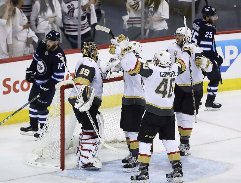 Vegas Golden Knights players congratulate goaltender Marc-Andre Fleury (left) after Sunday’s 2-1 victory over the Winnipeg Jets in Game 5 of the NHL Western Conference fi nals Sunday in Winnipeg. The expansion Golden Knights won the series 4-1 to advance to the Stanley Cup fi nal. 