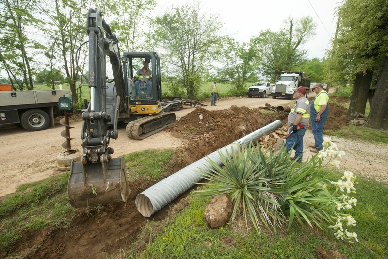 NWA Democrat-Gazette/BEN GOFF &#8226; @NWABENGOFF A crew from the Benton County Road Department replaces drainage culverts May 10 along Accident Road near Springdale.
