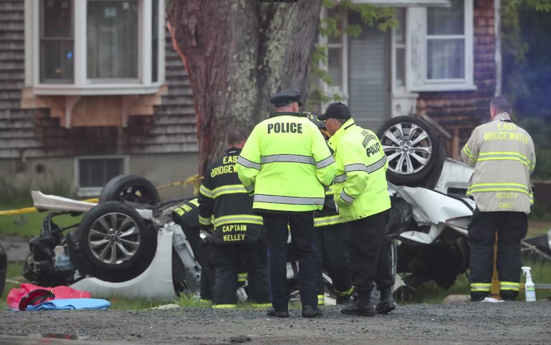 Police and firefighters investigate a multi fatal car crash in East Bridgewater, Mass., May 19, 2018. Police have identified teenagers killed in a Massachusetts car crash as local high school students. The five teens, all males, were traveling in one car in East Bridgewater when it crashed into a tree shortly after 4 p.m. Saturday. (Matthew J. Lee/The Boston Globe via AP)