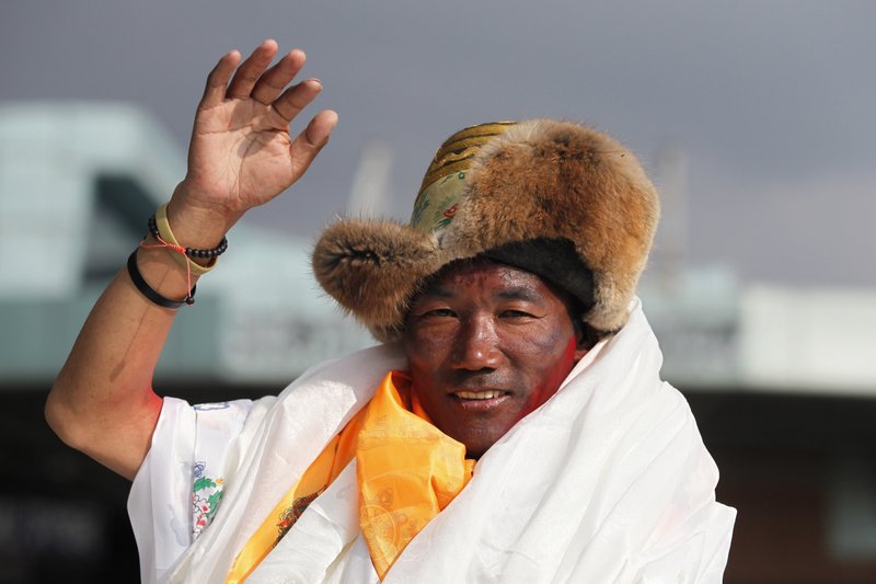 Nepalese veteran Sherpa guide, Kami Rita, 48, waves as he arrives in Kathmandu, Nepal, Sunday, May 20, 2018. Rita, scaled Mount Everest on Wednesday morning May 16 for the 22nd time, setting the record for most climbs of the world's highest mountain, officials said. (AP Photo/Niranjan Shrestha)
