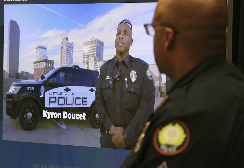 Little Rock police Sgt. Van Thomas watches one of the new Little Rock Police Department recruiting videos Monday during a news conference to announce a new campaign to attract and retain officers in the department. 
