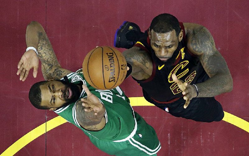 LeBron James of the Cleveland Cavaliers (right) drives to the basket against Marcus Morris of the Boston Celtics in the second half of Game 4 of the Eastern Conference fi nals Monday in Cleveland. James scored 44 points to power the Cavaliers to a 111-102 victory to tie the series at 2-2. 