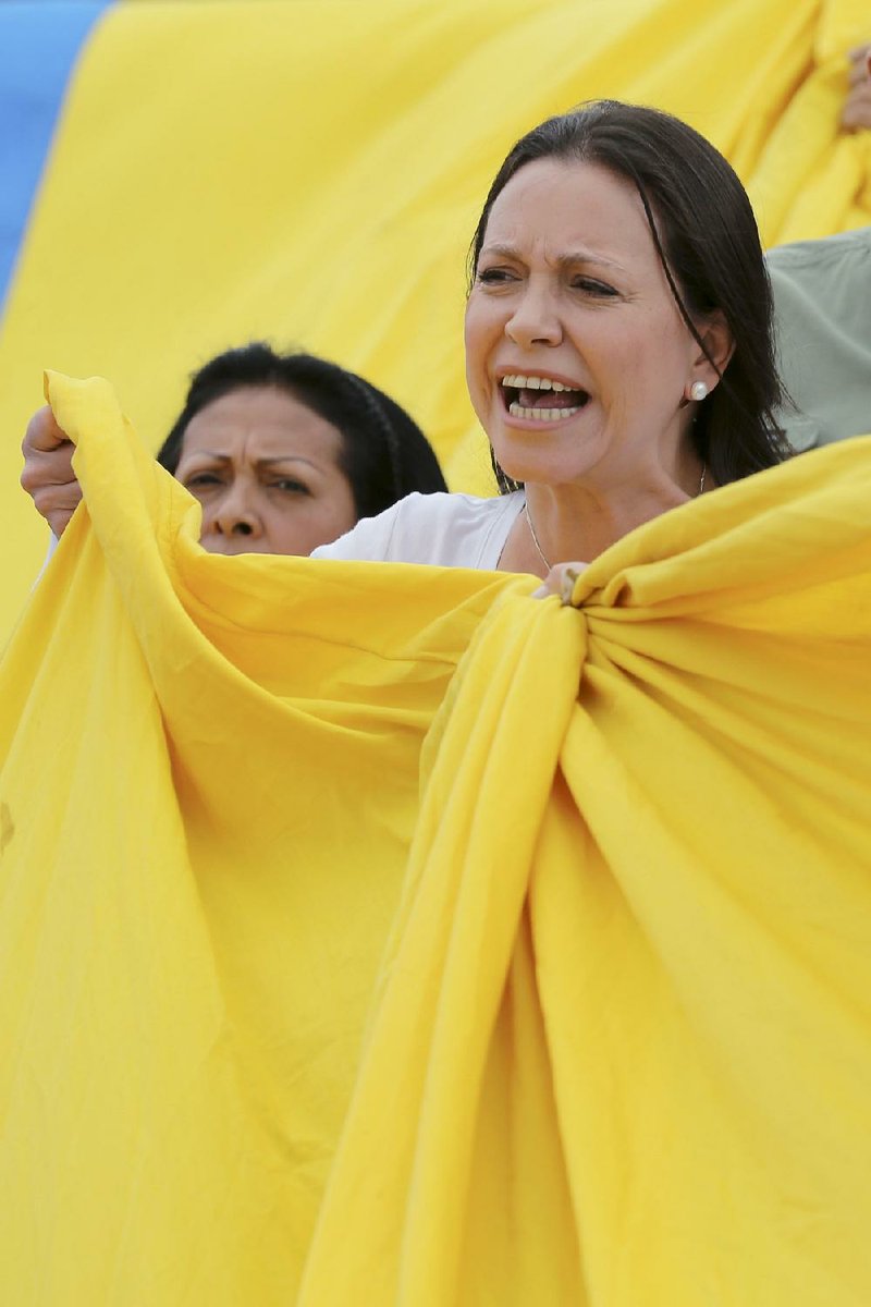 Opposition leader Maria Corina Machado wraps herself in a Venezuelan flag Monday in Caracas to protest Sunday’s election.
