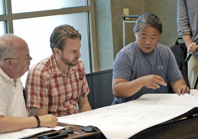 Ching Mong (from right), Matt Behrend and Todd Martin, all commissioners with the Fayetteville Advertising and Promotion Commission, go over proposed plans for the Walker-Stone House on Monday. 