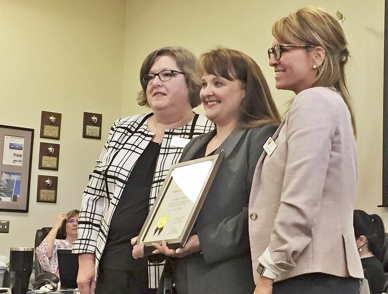 Ashley Williams (center), principal of Jones Elementary School in Bentonville, was honored during the School Board meeting Monday for achieving the designation of master principal through the Arkansas Leadership Academy. Brenda Tash (left), head of the master principal program, and Debbie Jones, superintendent of the Bentonville School District, posed with Williams for a picture during the board meeting. 