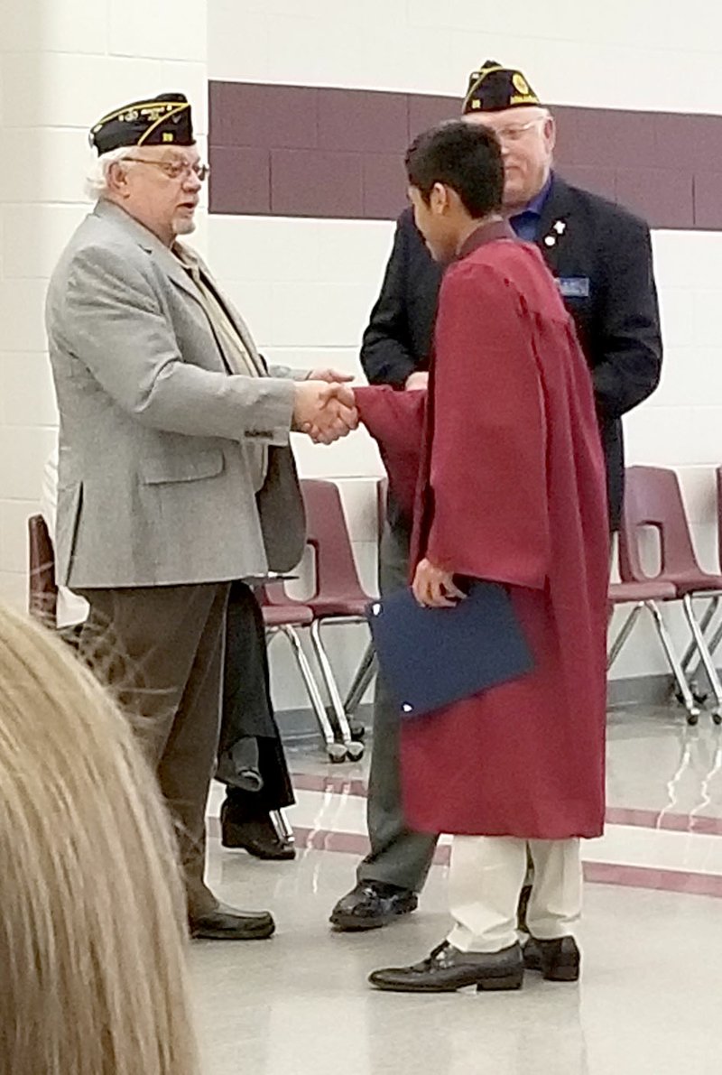 Westside Eagle Observer/LONNIE MOLL Vince Rajsombath receives the Americanism Award award from American Legion Post 29 of Siloam Springs at the Gentry Scholarship and Awards Ceremony held in the Gentry High School cafeteria on April 30. Awards and scholarships were presented to Gentry seniors at the annual event.