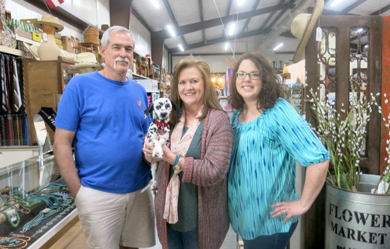 Westside Eagle Observer/SUSAN HOLLAND Steve and Jill Mitchael, of rural Gravette, pose with Deonne Underhill, of Pea Ridge, who assists them on weekdays, and Gracie, a miniature dalmation who serves as store mascot, at their new business, 72 West. The retail store, which opened April 30 at 11507 Hwy. 72 in Centerton, has an extensive inventory of antiques, home furnishings, collectibles, jewelry and more.