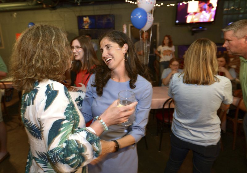 NWA Democrat-Gazette/ANDY SHUPE Nicole Clowney, Democratic candidate for State House District 86, gets a hug Tuesday, May 22, 2018, from volunteer Nancy Firman of Fayetteville after early voting results were announced during a watch party at U.S. Pizza in Fayetteville.
