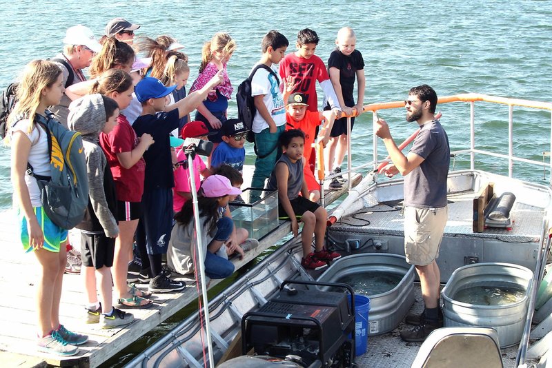 Photo submitted Bella Vista POA Biologist Chris Fuller (in boat) is shown describing Bella Vista lakes' fish and turtle species to Baker Elementary students.