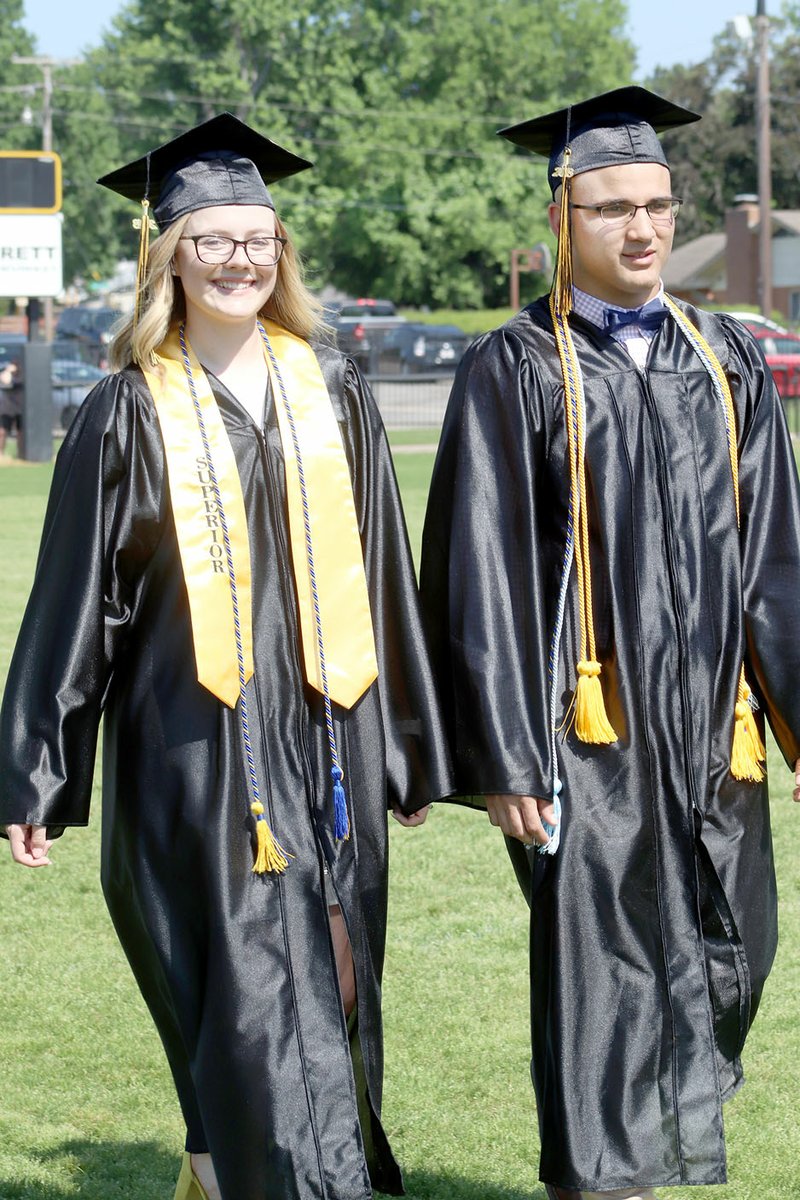 LYNN KUTTER ENTERPRISE-LEADER Baylie Lanier and Anthony Johnson walk to their seats during the processional for Prairie Grove's 2018 graduation ceremony. Prairie Grove High Band played "Pomp and Circumstance" for the procession and Prairie Grove High Choir sang the National Anthem and Prairie Grove Alma Mater.