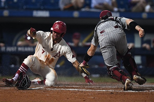 Arkansas' Jack Kenley scores ahead of the tag by South Carolina catcher Hunter Taylor during a game Wednesday, May 23, 2018, at the SEC Tournament in Hoover, Ala. 