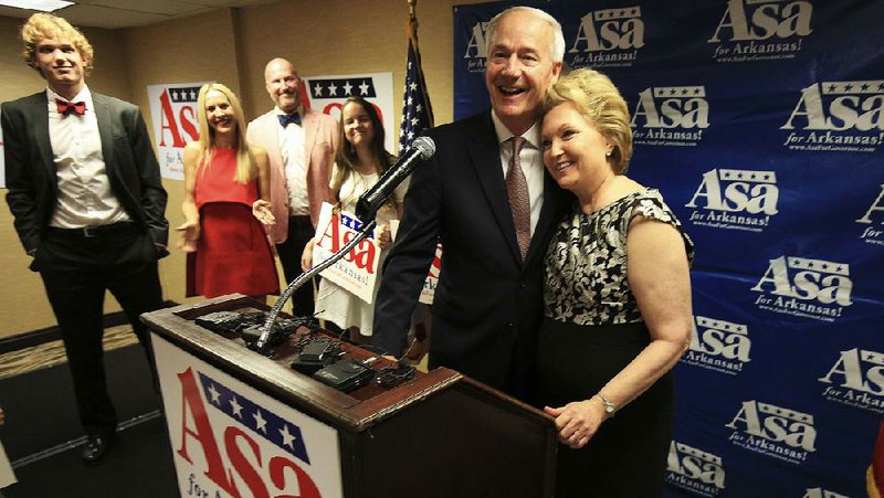 Gov. Asa Hutchinson celebrates Tuesday night with his wife, Susan Hutchinson, and family members at a watch party in Little Rock.  