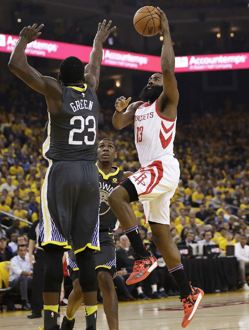 Houston guard James Harden (right) shoots over Golden State forward Draymond Green during the Rockets’ 95-92 victory over the Warriors on Tuesday in Game 4 of the NBA Western Conference finals. Harden led the Rockets with 30 points.  