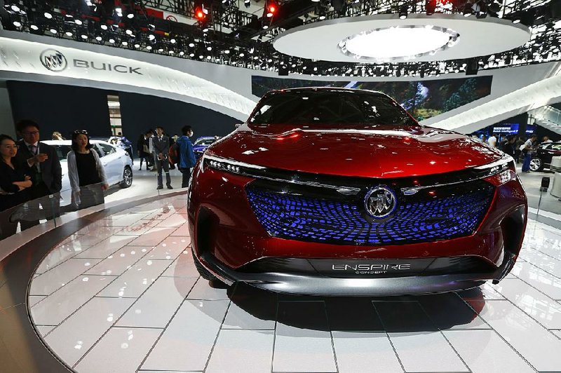 Visitors look at a Buick Enspire concept car on display at Auto China 2018 in Beijing in April. China said Tuesday it will reduce its auto import tariffs from 25 percent to 15 percent effective July 1.  