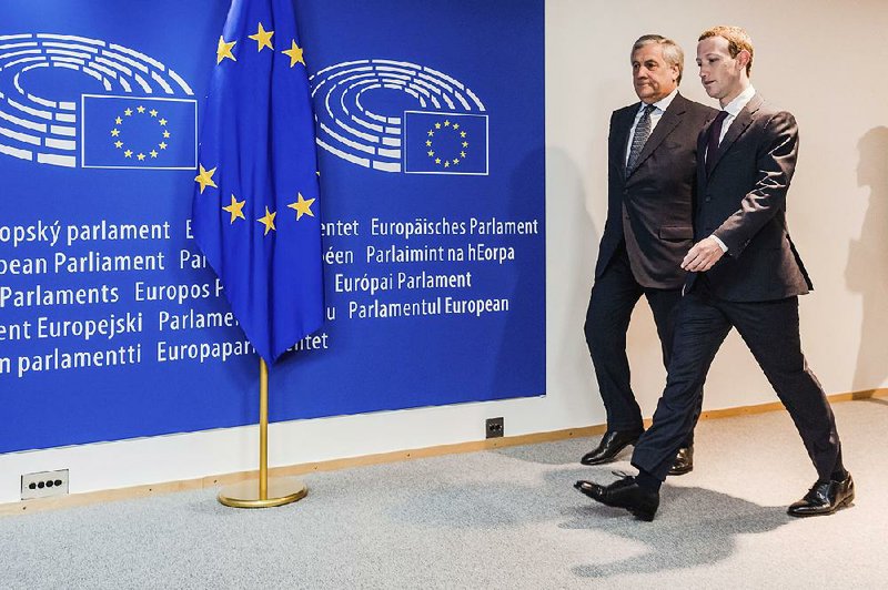European Parliament President Antonio Tajani (left) escorts Facebook Chief Executive Officer Mark Zuckerberg upon his arrival at the EU Parliament in Brussels on Tuesday. European Union lawmakers grilled Zuckerberg about data protection standards at the Internet giant at a hearing.  