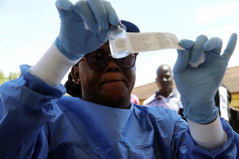 A health worker prepares an Ebola vaccine to administer to health workers Monday in Mbandaka, Congo.  
