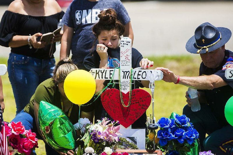 Mourners gather Tuesday around a memorial for Santa Fe High School freshman Aaron Kyle McLeod, who was killed in Friday’s shooting in Santa Fe, Texas.  
