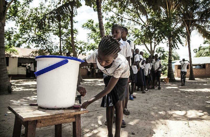 Schoolchildren wait in line Tuesday to wash their hands before entering a classroom in Mbandaka, Congo, as efforts ramp up to try to prevent the spread of Ebola.  