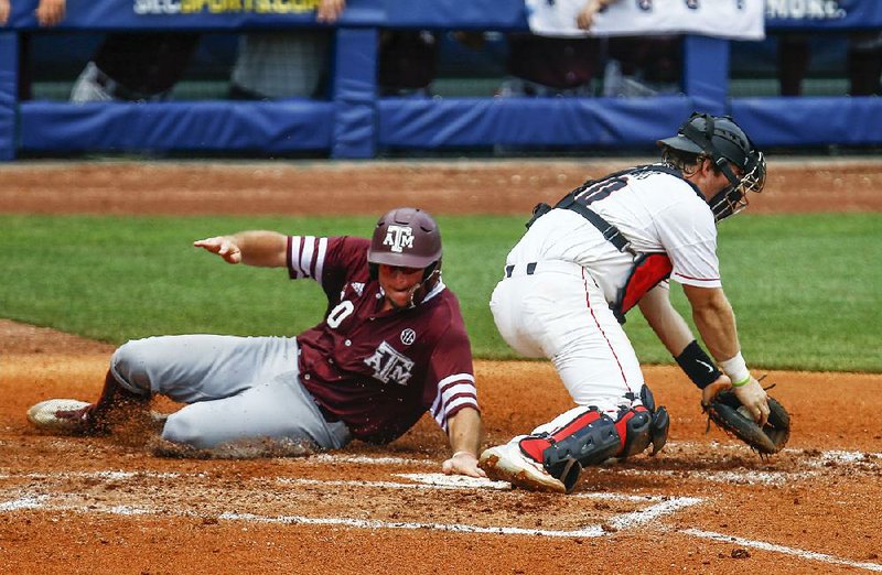 Texas A&M infielder Chris Andritsos (left) beats the tag of Georgia catcher Mason Meadows as he slides into home plate Wednesday during the fourth inning of the Aggies’ 7-0 victory over the Bulldogs at the SEC Tournament in Hoover, Ala. Andritsos hit two home runs and drove in four in the victory. 